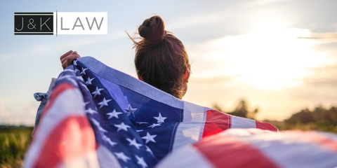 Woman holding U.S flag behind her
