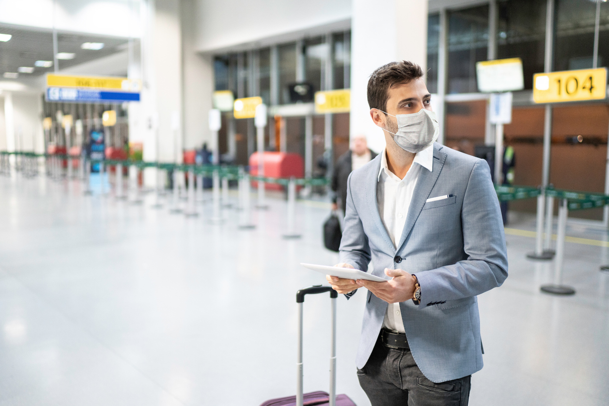 A man in a suit looking around a nearly empty airport